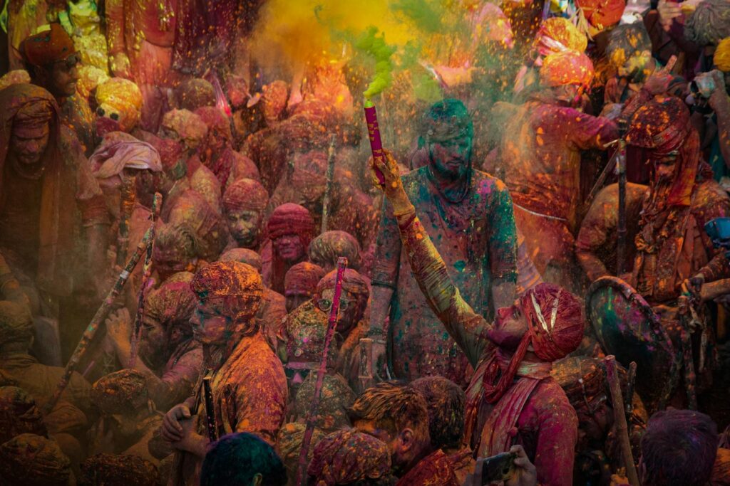 Colorful Holi festival with celebrating crowd in Mathura, India.